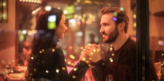 couple holding hands together at a restaurant