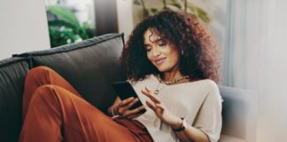 woman sitting on the couch on her phone