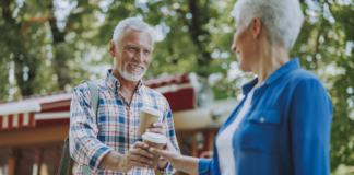 man handing woman coffee