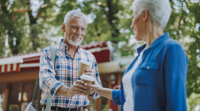 man handing woman coffee