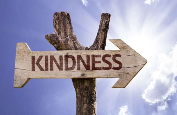 kindness sign with arrow on sunny background