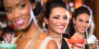 multicultural group of women after work drinking cocktails in bar