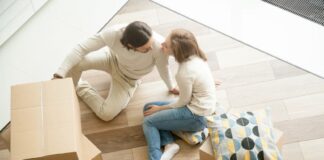 Couple sitting on floor with boxes, moving day, top view