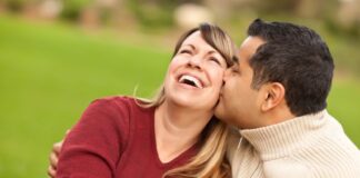 happy woman wearing red sleeve kissed by her husband