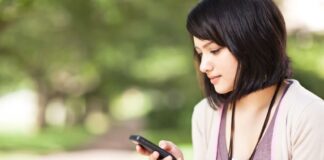 short haired woman using mobile phone at the park