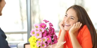 guy giving flowers to a pretty smiling girl