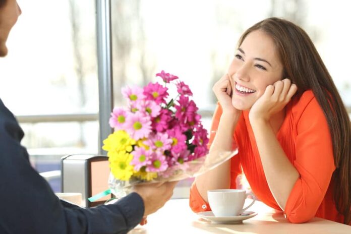 guy giving flowers to a pretty smiling girl