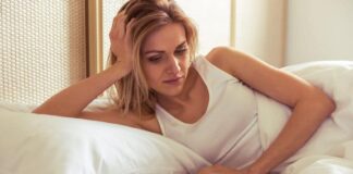 woman lying on bed waiting for a text