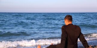 lonely man sitting at the beach