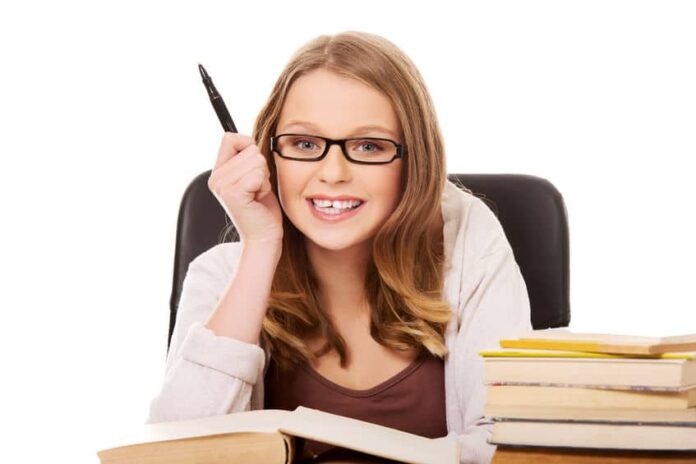 young intelligent lady wearing eyeglasses and holding a pen on her right hand