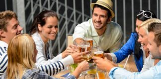 young people celebrating outside and drinking wine