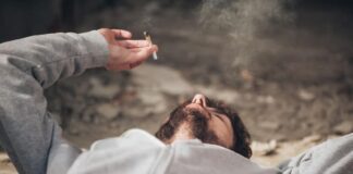 guy lying on the floor while smoking