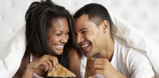 couple eating breakfast together on bed