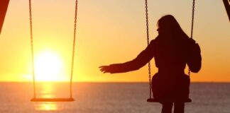 silhouette of woman alone at beach under a beautiful sunset