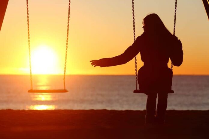 silhouette of woman alone at beach under a beautiful sunset