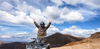 man riding an atv under a beautiful sky