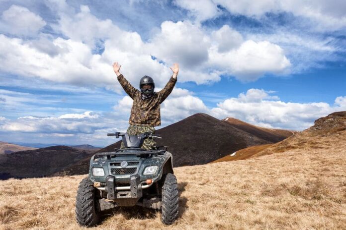 man riding an atv under a beautiful sky