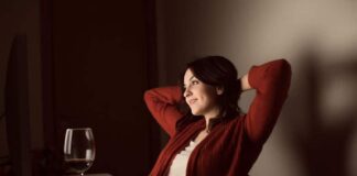 attractive beautiful woman wearing red sweaters sitting and drinking wine while dating online