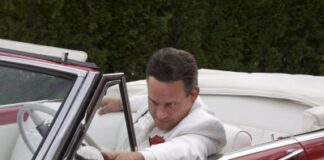 narcissistic man looking at his red cars mirror