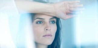 Lovely young lady looking through glass window