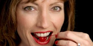 a woman with a cherry inside her mouth