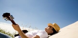 a man playing the guitar under the heat of the sun