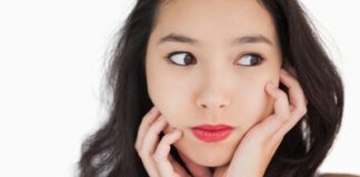 Woman looking afraid against white background