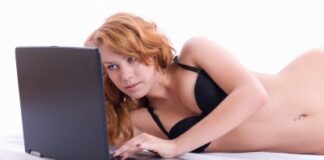 Sexy woman using laptop computer at the bed