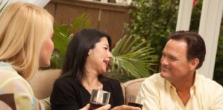 2 women and 1 man drinking wine, on the couch