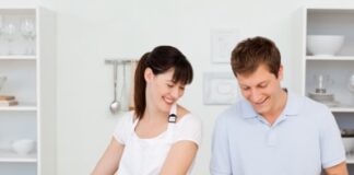 Lovers washing dishes together in their kitchen