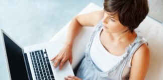 Top view of young woman chatting on laptop at home