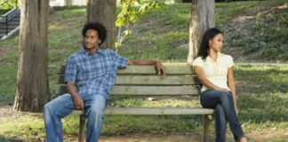 couple sitting far from each other on a bench