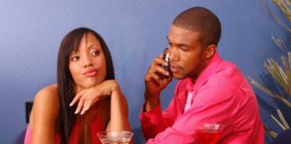 couple in martini bar, girl annoyed due to boyfriend taking on his phone