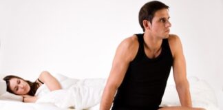 man sitting on the edge of the bed, woman looking at him