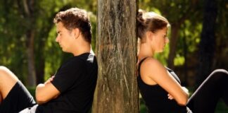 young couple separately sitting under a tree, being in conflict