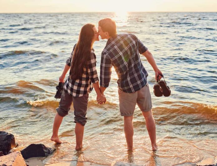 A couple holds hands and kisses on one of the most romantic getaways in Michigan