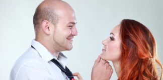 man holding his woman's chin, woman holding her man's tie