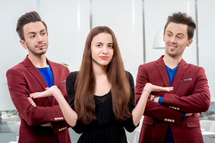 woman in between two men having a hard time choosing