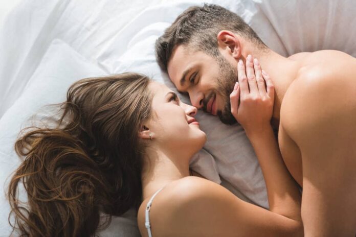 A couple snuggles together enjoying the benefits of cuddling