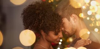 A man embraces his date after reading romantic Christmas messages for him