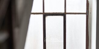 brunette woman sitting in a window seat reading a book