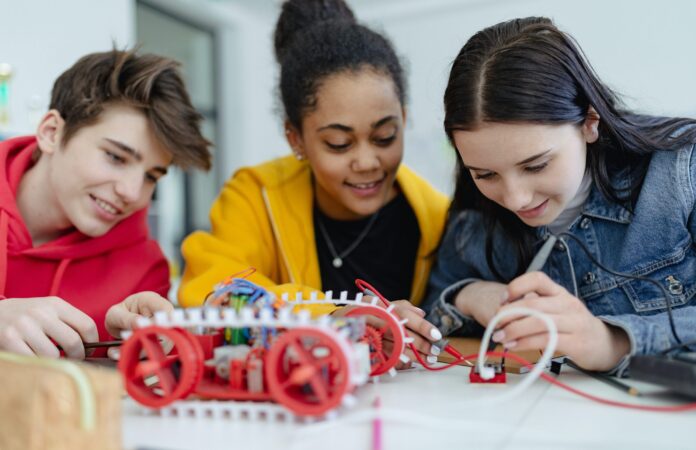 three students working on robotics