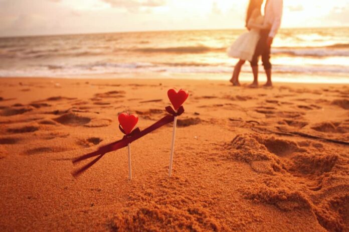 A couple walk on the beach during a romantic Valentine's Getaway