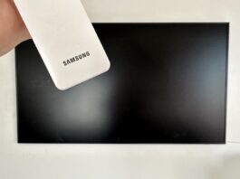 picture of a samsung remote in front of a samsung frame tv