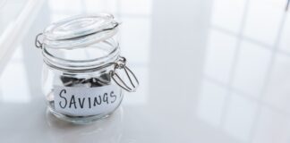 jar labeled savings with money in it 