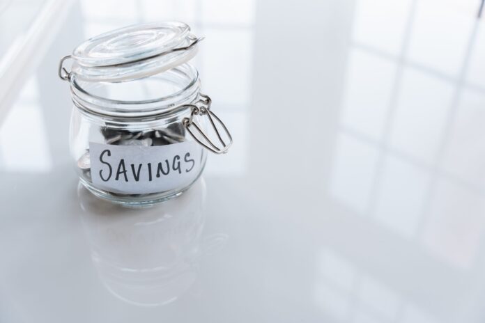 jar labeled savings with money in it 