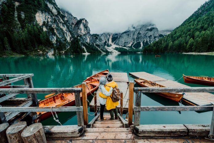 hiking couple standing in front of a lake