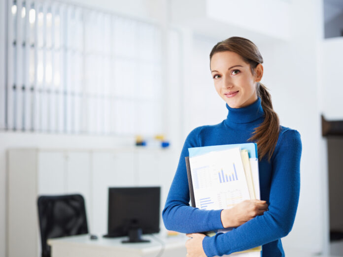 business woman holding reports and looking at camera. Copy space