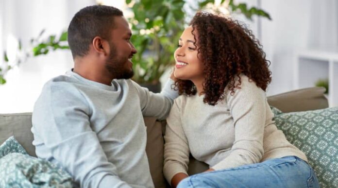 couple sitting on couch looking at one another