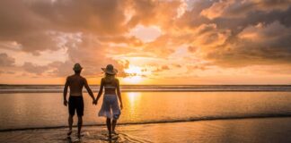 couple holding hands on a beach during sunset - a romantic scene for a honeymoon in south america